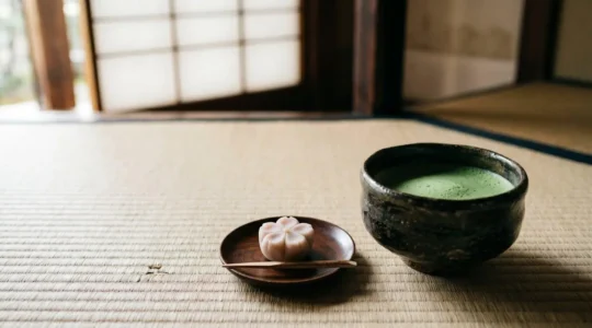 Scène intime de cérémonie du thé japonaise avec bol à matcha et pâtisserie wagashi sur tatami